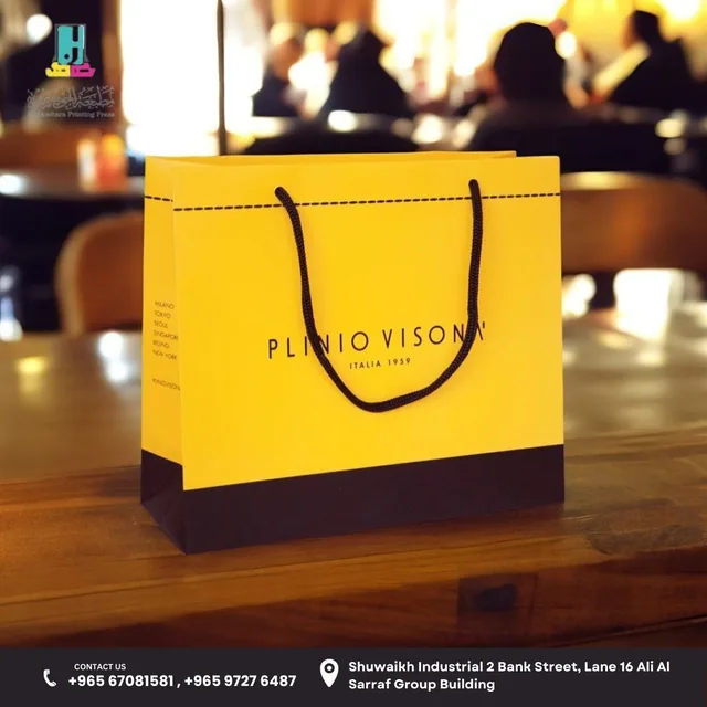 Yellow paper bag with black rope handles