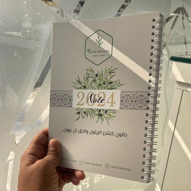 Spiral planner with printed cover held in hand
